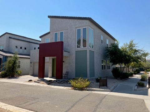 a gray house with a red structure in front of it