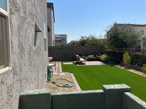 a backyard with a green lawn and a garden