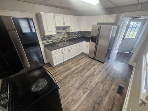 A kitchen with a black stove top oven and a black refrigerator.