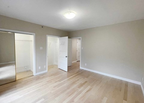 a living room with a hard wood floor and a mirrored closet