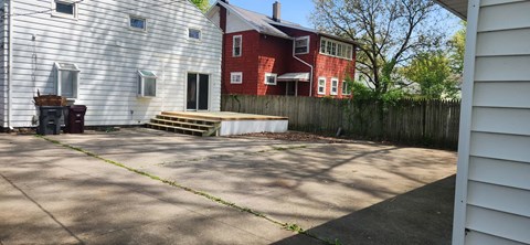 the back yard of a house with a patio and a deck