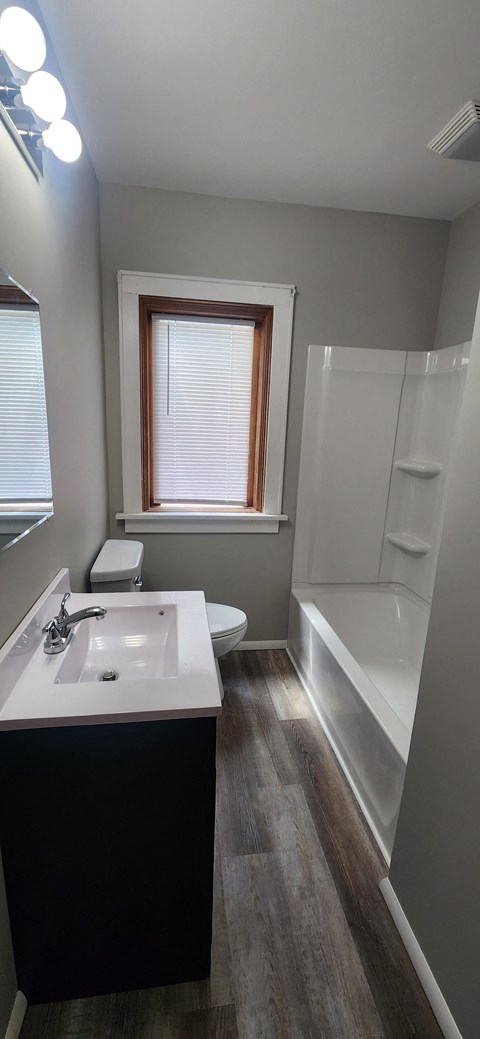 a small bathroom with a sink toilet and bath tub