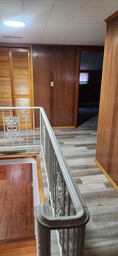 a view of a staircase in a building with wood and stainless steel railing