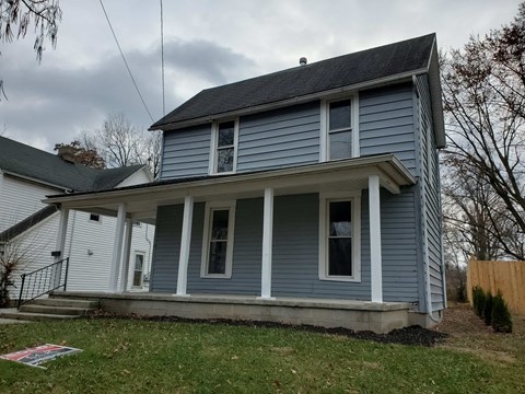 the front of a blue house with a porch