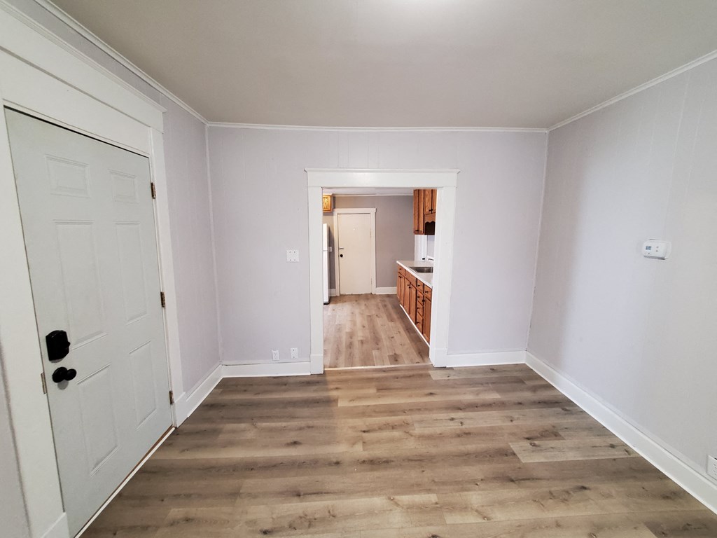 an empty living room with white walls and wooden floors