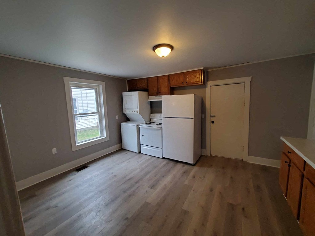 a kitchen with a white refrigerator and a window