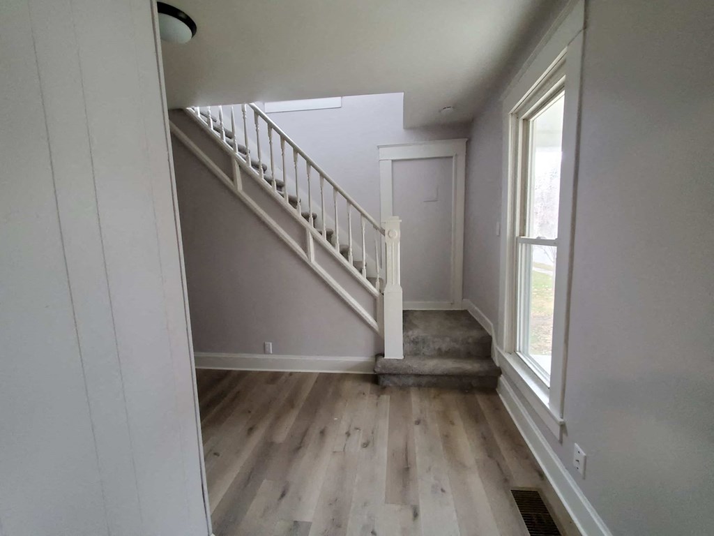 a stairwell in a home with wooden floors and a white door