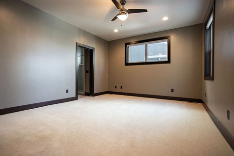 an empty room with a ceiling fan and a window
