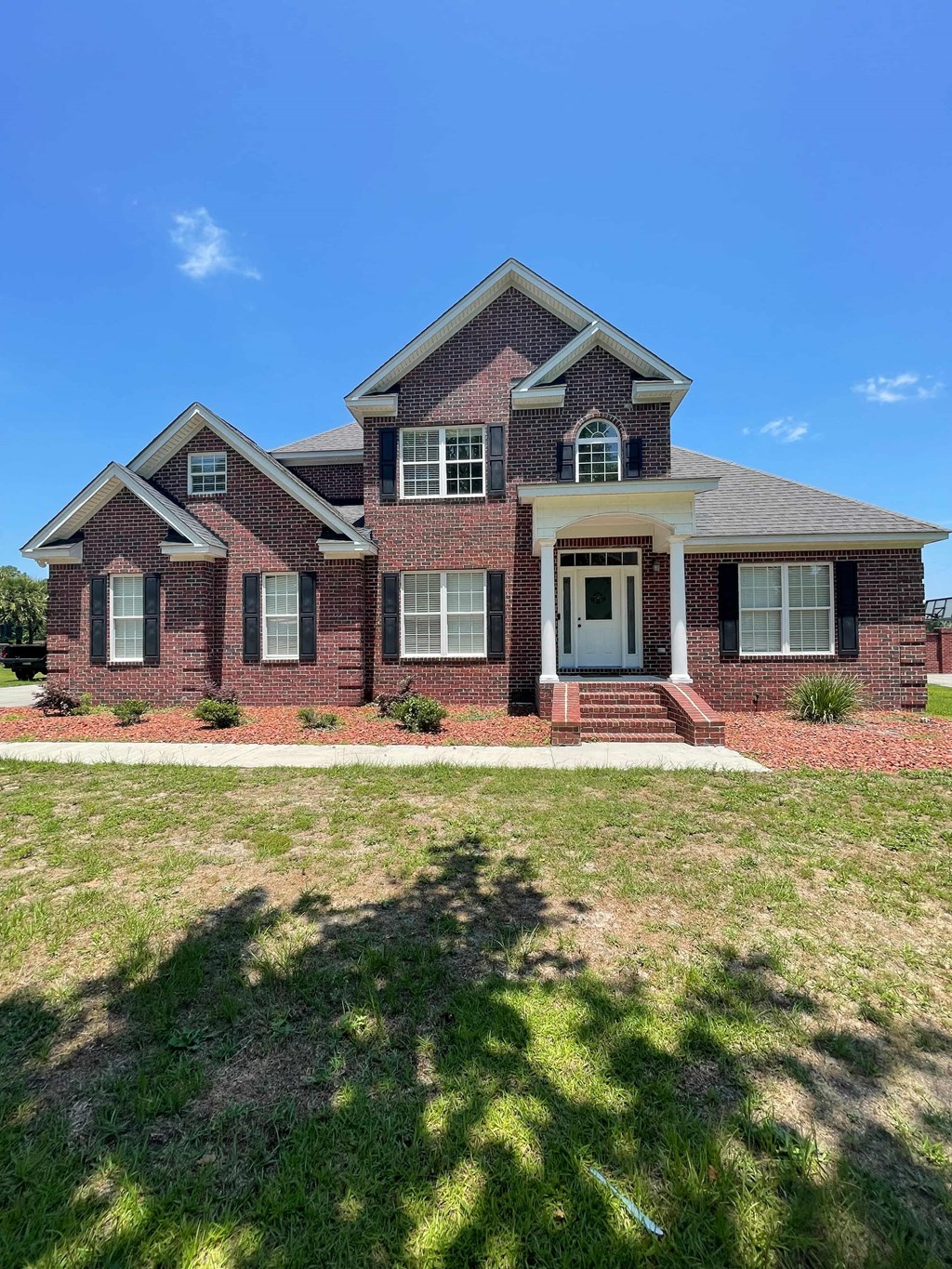 a large brick house with a lawn in front of it