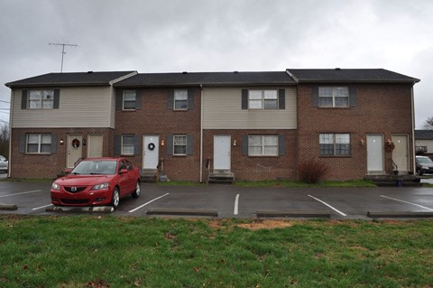 a red car parked in front of an apartment building