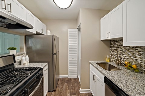 a kitchen with granite counter tops and a stainless steel refrigerator