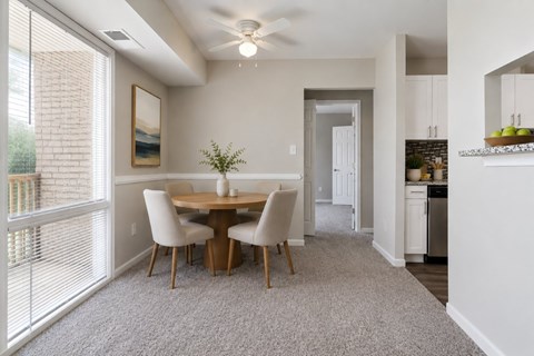 A dining room with a table and chairs.
