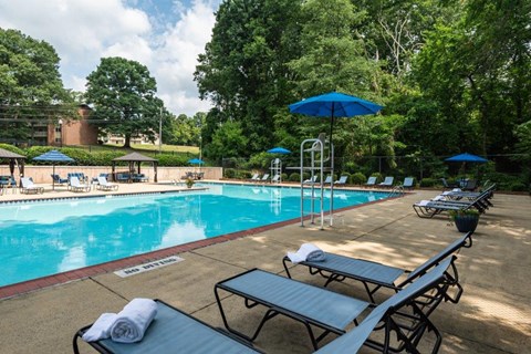 a swimming pool with tables and umbrellas and chairs around it
