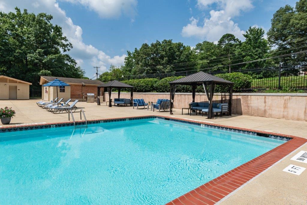 a resort style pool with chairs and gazebos on the side