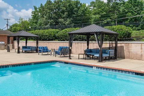 a swimming pool with chairs and gazebos next to a resort style pool