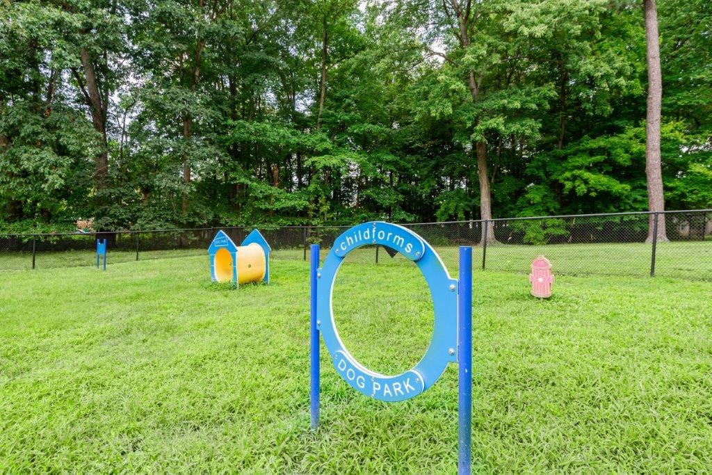 a park with a playground and a circle sign in the grass