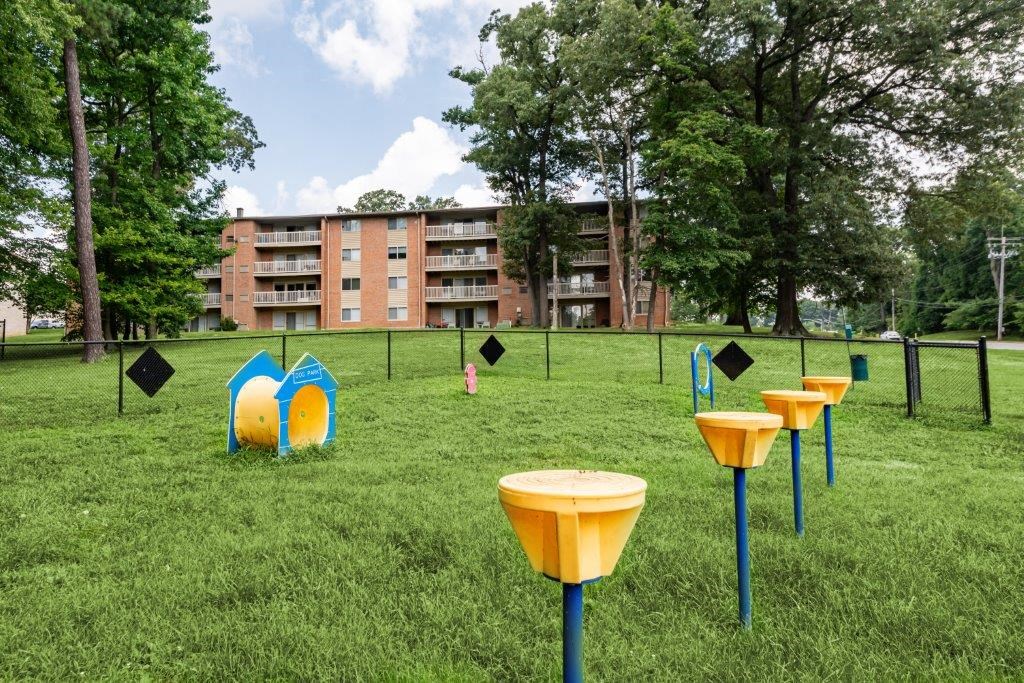 a group of yellow and blue tables in the middle of a grass field