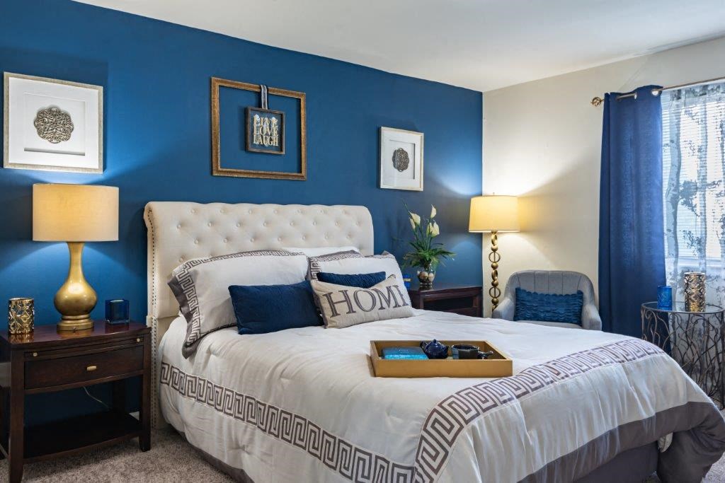 a bedroom with blue walls and a white bed