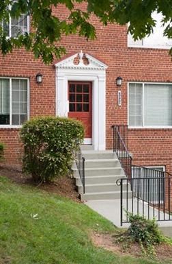 a red brick building with a red door and stairs