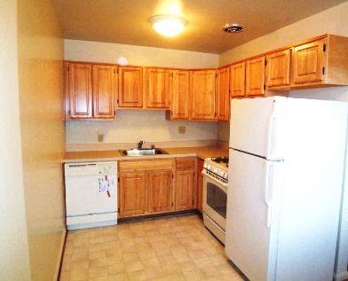 a kitchen with white appliances and wooden cabinets