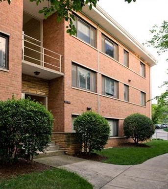 a brick building with a balcony and a sidewalk