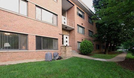 an apartment building with a balcony and a suitcase on the grass