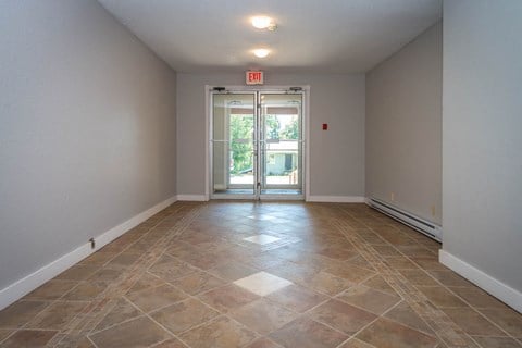 A room with a tiled floor and a door leading outside.