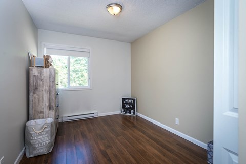 A room with a wooden floor and a window.