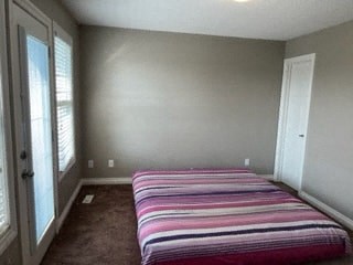 a bedroom with a bed and a large window