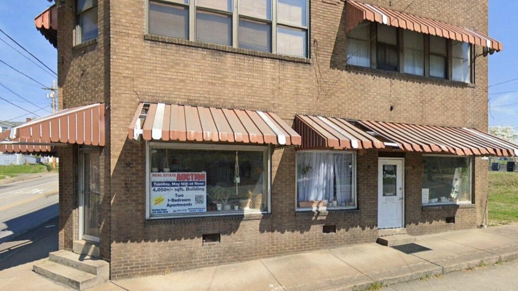 the front of a brick building with a sign in the window