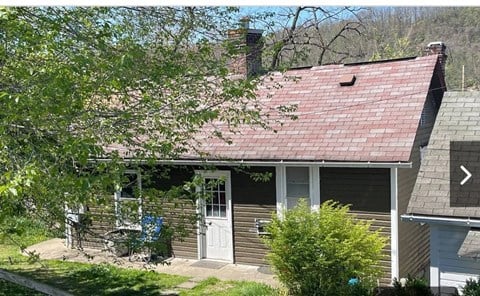 a small house with a red roof and a white door
