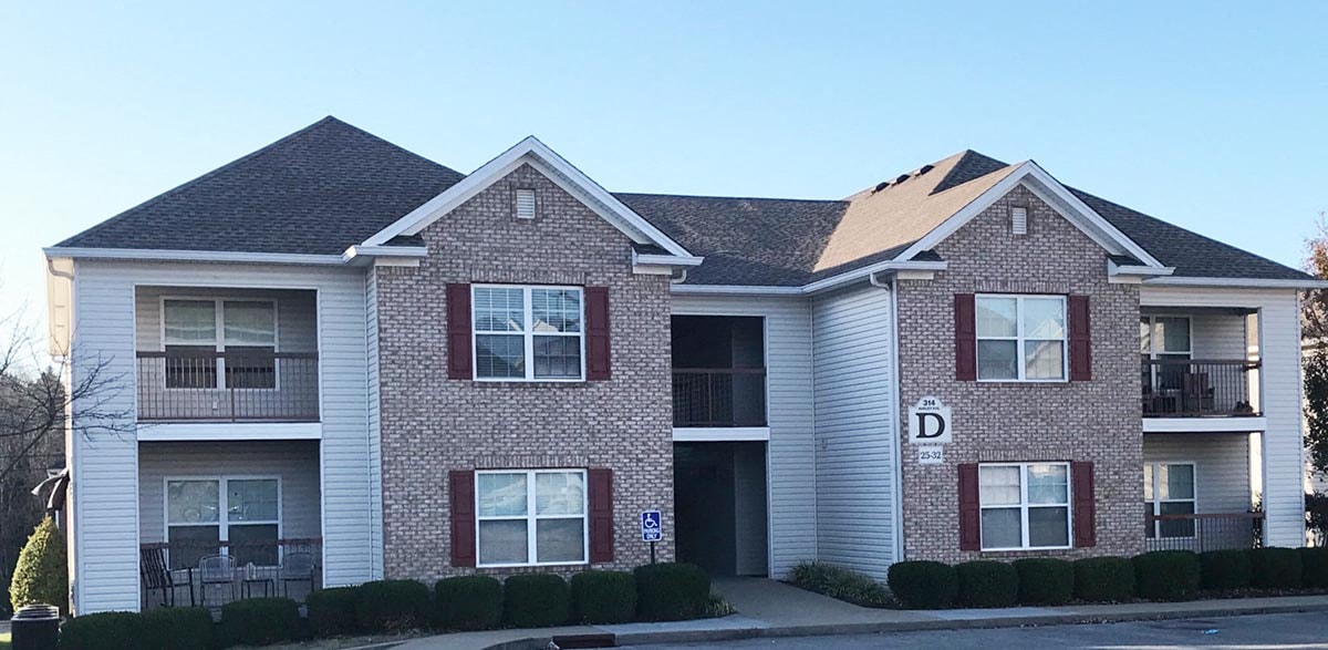 a brick house with a sidewalk in front of it