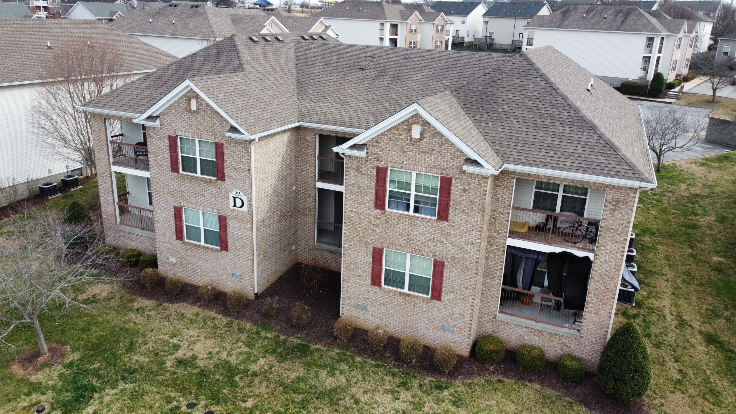 an aerial view of a brick house with red shuttered windows