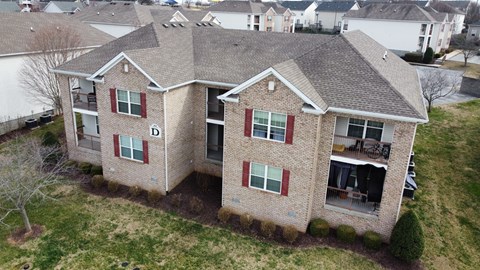 an aerial view of a brick house with red shuttered windows