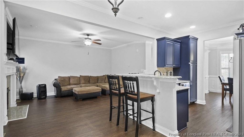 a living area with a kitchen and a living room with a couch