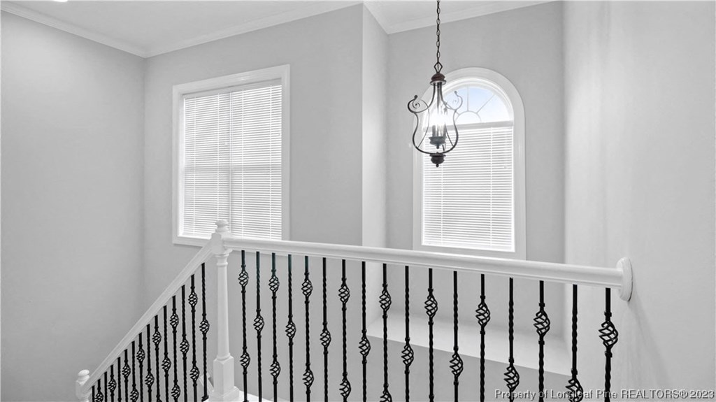 a stairway with a wrought iron railing and a window with a light