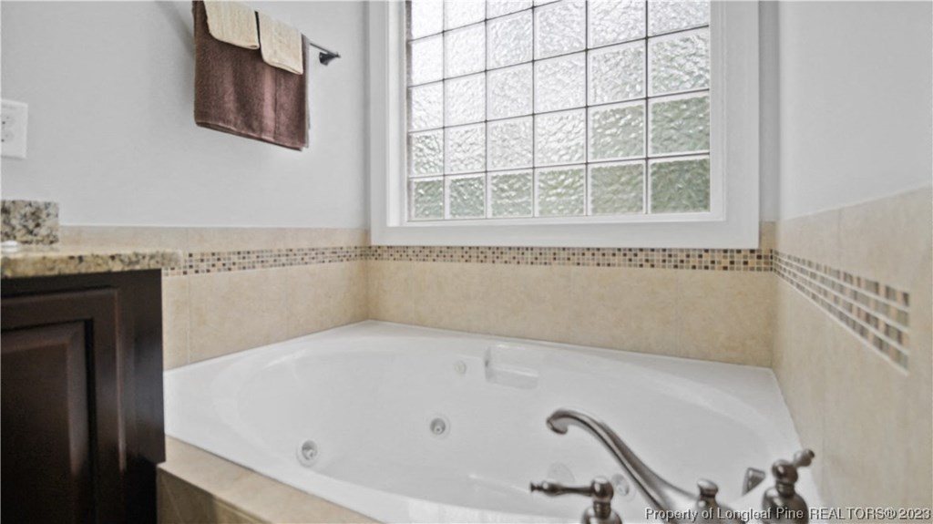 a large jacuzzi tub in a bathroom with a window