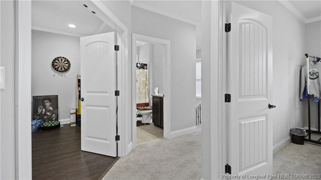 a bedroom with white doors and a hallway with a closet and a bathroom