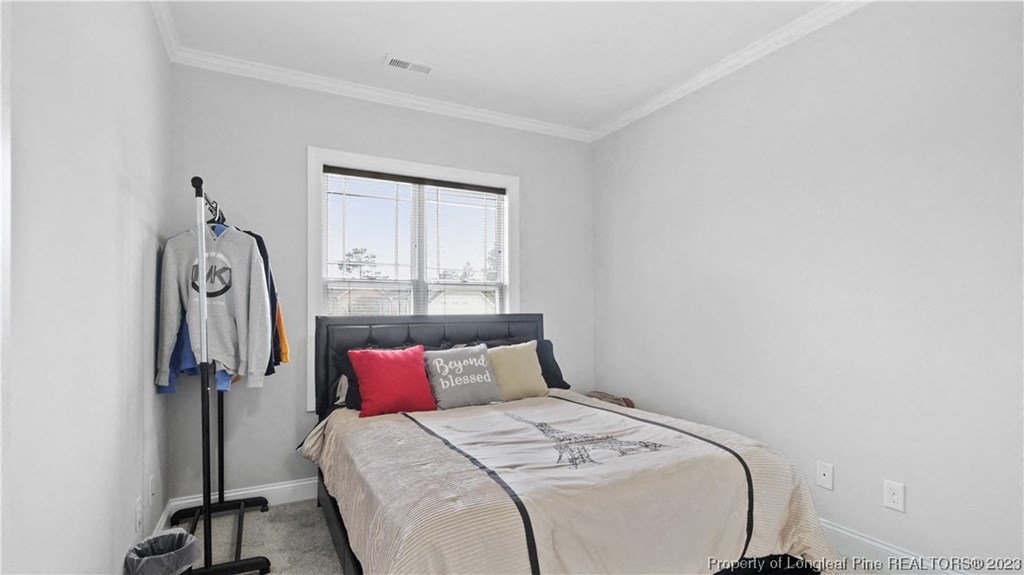 a white bedroom with a bed and a window