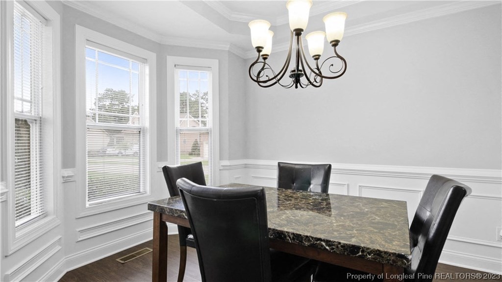 a dining room with a table and chairs and a chandelier