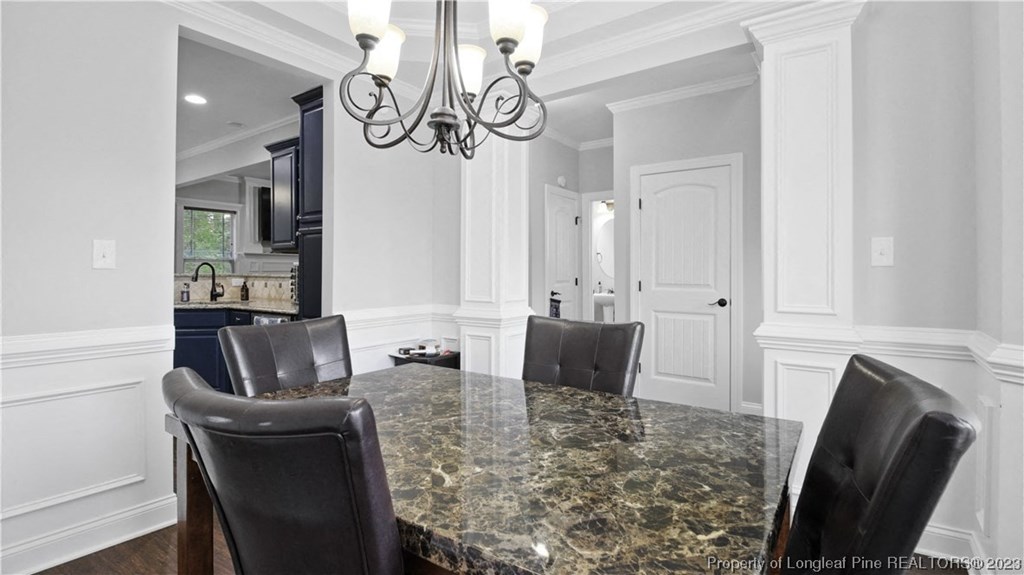a kitchen with a marble table and black chairs