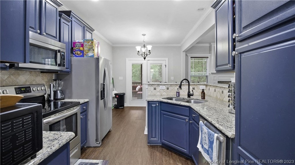 a kitchen with blue cabinets and marble counter tops