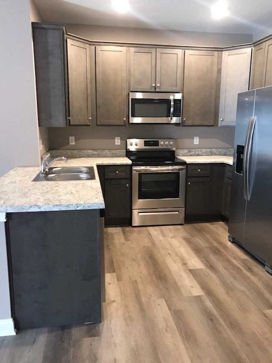 a kitchen with wooden floors and stainless steel appliances