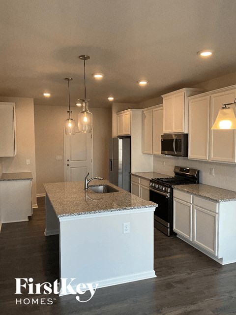 a kitchen with white cabinets and granite counter tops
