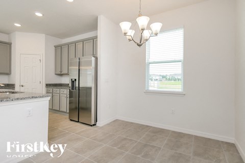 a white kitchen with a stainless steel refrigerator and a window
