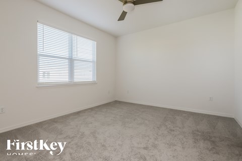 the living room of a home with a carpet and a window
