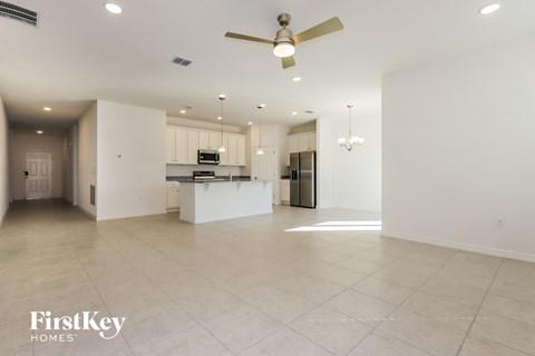 an empty kitchen and living room with a ceiling fan