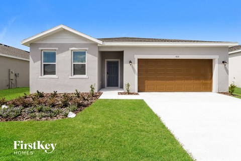 a house with a garage door and a lawn