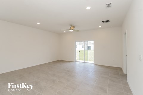 an empty living room with white walls and a sliding glass door
