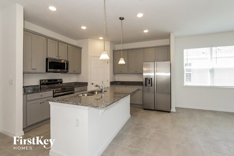 a large kitchen with stainless steel appliances and granite counter tops